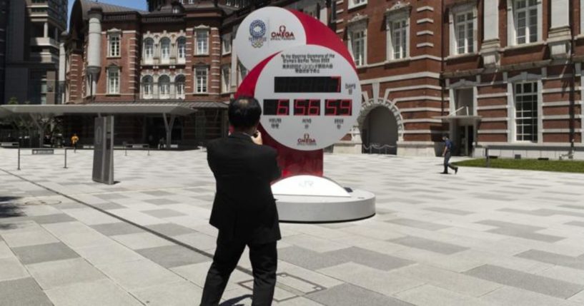 A man takes a picture of a countdown clock that shows seven more days to go before the opening ceremony of the Olympic Games in Tokyo on Friday.