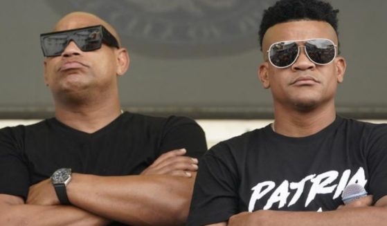 Cuban reggaeton musicians Alexander Delgado, left, and Randy Malcom, both with the band Gente de Zona, look out into a crowd of demonstrators, Wednesday in Miami's Little Havana neighborhood, as people rallied in support of anti-government demonstrations in Cuba. Gente de Zona's song "Patria y Vida," which means Homeland and Life, has become the anthem of the demonstrations and is a play on the phrase "Patria o Muerte," Homeland or death, which was a phrase in the Cuban Revolution.