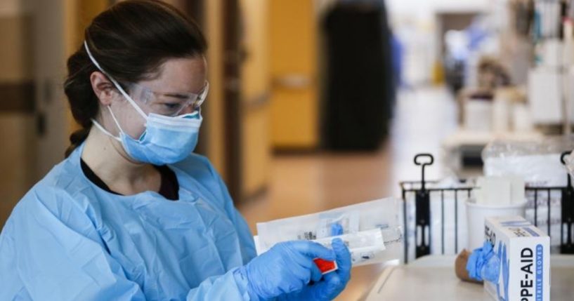 Nurses and doctors in the CoxHealth Emergency Department in Springfield, Missouri, don personal protective equipment to treat patients with COVID-19 on Friday.