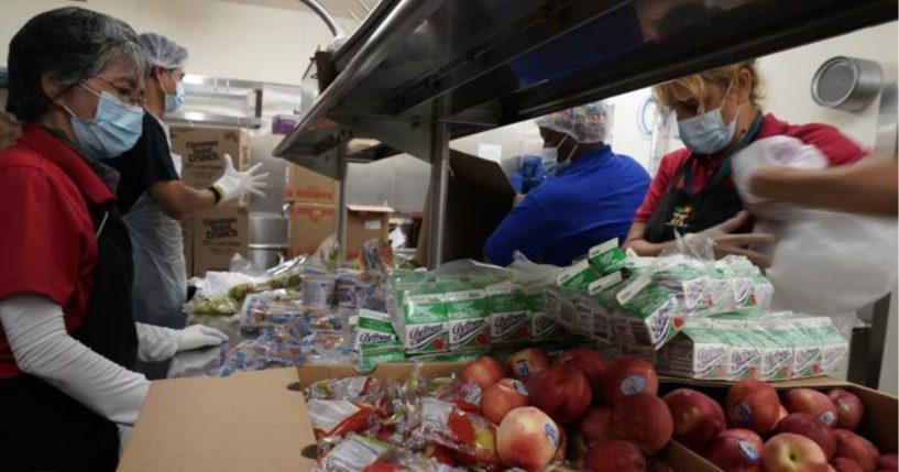 Los Angeles Unified School District food service workers from left, Tomoko Cho, Aldrin Agrabantes, April Thomas, and Marisel Dominguez, pre-package hundreds of free school lunches in plastic bags on Thursday at the Liechty Middle School in Los Angeles.