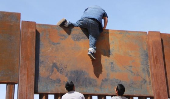 Young Mexicans help a compatriot to climb the metal wall that divides the border between Mexico and the U.S. to cross illegally to Sunland Park, New Mexico, from Ciudad Juarez, Mexico, on April 6, 2018.