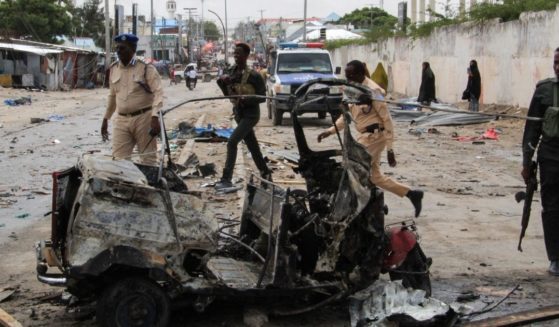 Police officers patrol by the wreckage of a car at the scene of suicide car bomb attack that targeted the city's police commissioner in Mogadishu, Somalia, on July 10. The al-Shabaab terrorist group claimed responsibility for the attack.