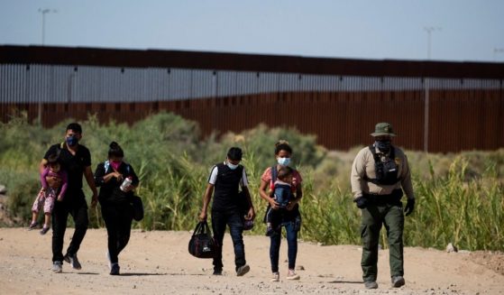 Migrants from Guatemala follow an officer after illegally crossing the border between the United States and Mexico into Yuma, Arizona, on May 12.