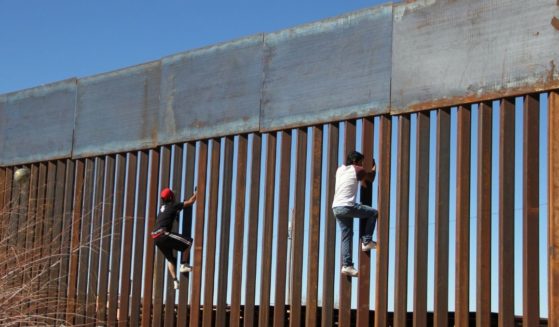 People climb the border wall between Mexico and the U.S. in Ciudad Juarez, Mexico, on Jan. 26, 2017.