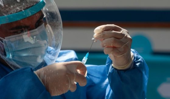 A health care worker prepares a dose of the Pfizer vaccine on Friday in Quito, Ecuador.