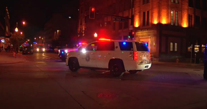 A police vehicle with flashing lights sits outside the Maven Hotel in Denver during a weapons raid.