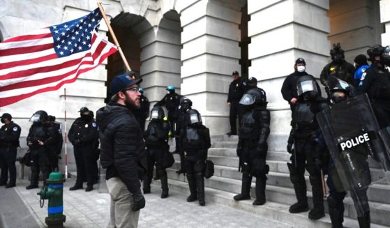 A protester confronts police and security forces at the U.S. Capitol in Washington, D.C., on Jan. 6, 2021.