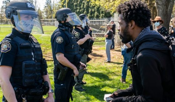 A protester yells at a Portland, Oregon, officer after a fatal police shooting in the city's Lents Park on April 16.