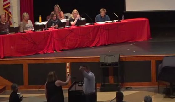 Anita Edgarian, bottom left, speaks with local school board president Chris McCune, bottom right, at a meeting on July 26, 2021, in West Chester, Pennsylvania.