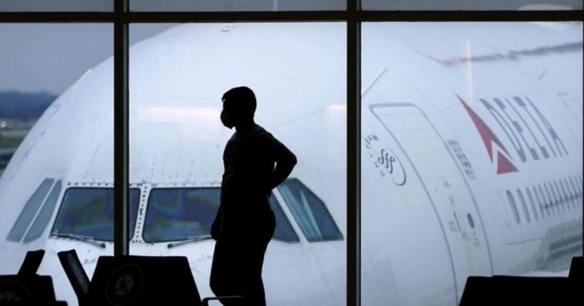 A passenger wearing a mask stands at the Hartsfield-Jackson International Airport in Atlanta on Feb. 18, 2021.