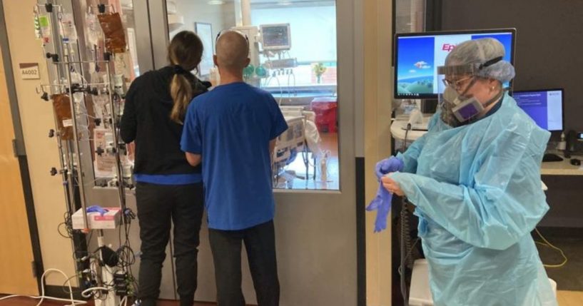 A nurse and two visitors stand outside the intensive care unit at the Salem Hospital in Salem, Oregon, on Friday.