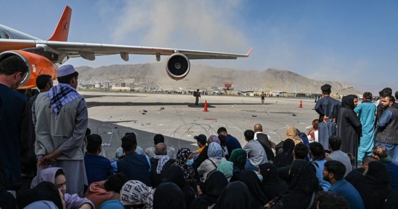 A crowd of Afghan people is seen sitting at the airport in Kabul in Afghanistan on Monday.