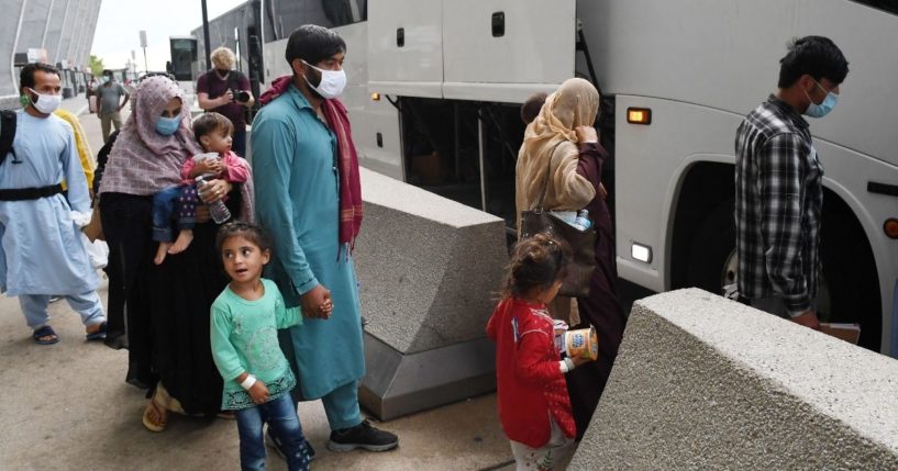 Afghan refugees board a bus after arriving at Dulles International Airport on Aug. 27, in Dulles, Virginia after being evacuated from Kabul following the Taliban takeover of Afghanistan.