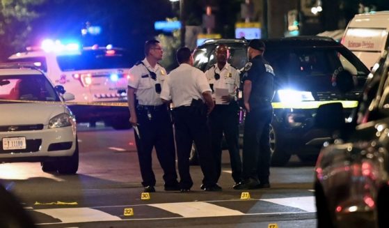 Police officers work at the scene of a shooting outside a restaurant in Washington, D.C., on July 22, 2021.