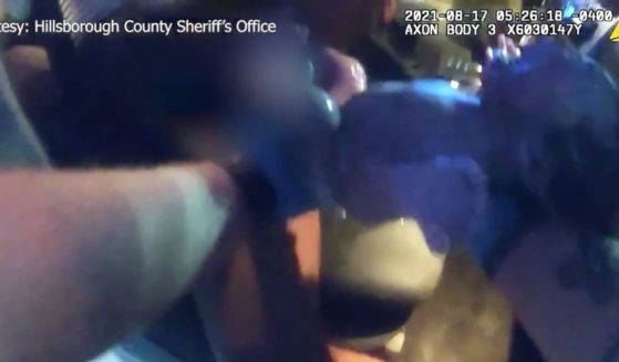 A Florida sheriff's deputy holds a newborn baby after assisting a laboring mother in a car on Tuesday.