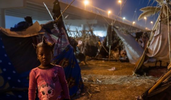 A Haitian girl stands at a migrant camp at the U.S.-Mexico border on Tuesday in Del Rio, Texas.