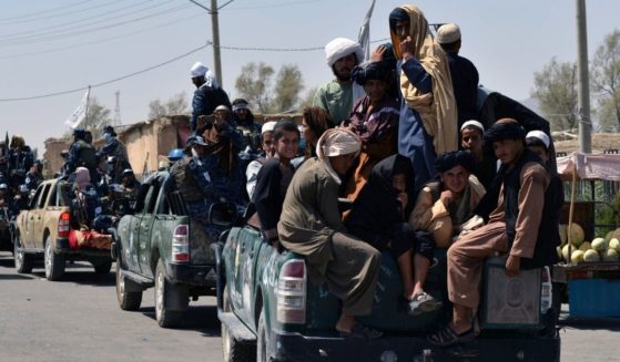 Taliban fighters atop vehicles parade along a road to celebrate after the U.S. pulled all its troops out of Afghanistan in Kandahar on Wednesday.