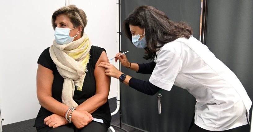 Care worker Jen Madghachian receives her COVID-19 booster vaccination at the MedMart pharmacy on Monday in Borehamwood, England.