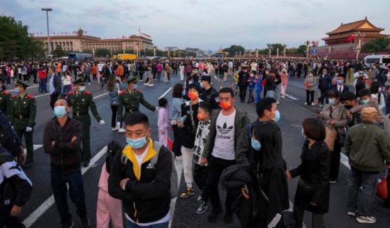 Thousands of people disperse after gathering in Tiananmen Square for a flag raising ceremony on Friday.