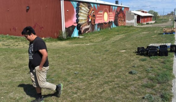 A young man walks past the U.S. Post Office on the Standing Rock Sioux Reservation in Cannon Ball, N.D., on May 20, 2021.