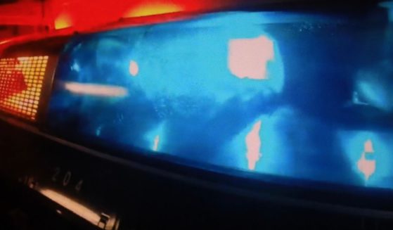 A stock photo shows sirens flashing on top of a police car.