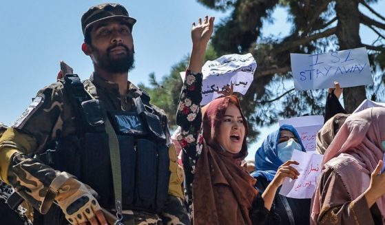 Afghan women march next to a Taliban fighter during an anti-Pakistan demonstration near the Pakistan embassy in Kabul on Sept. 7.