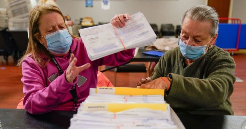 Board workers Bernadette Witt, left, and JoAnn Bartlett, right, process mail-in ballots for Bergen County in Hackensack, New Jersey. Tuesday's gubernatorial election has been decided in favor of Democratic incumbent Phil Murphy, but questions have arisen regarding irregularities involving 56 voting machines.