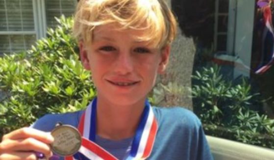 Oakley Debbs holds a medal he earned before his death in 2016.