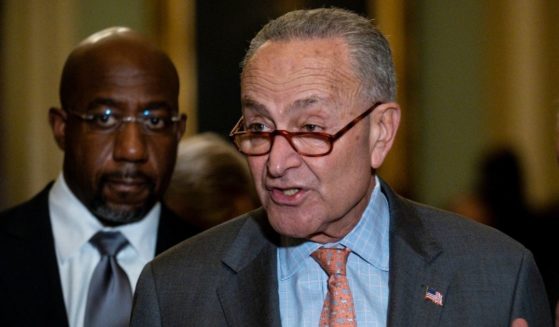 Senate Majority Leader Chuck Schumer addresses reporters after a Democratic caucus luncheon at the Capitol on Nov. 2 with Georgia Sen. Raphael Warnock, left.