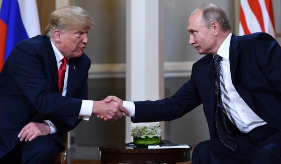 Former U.S. President Donald Trump, left, and Russian President Vladimir Putin shake hands before a meeting in Helsinki, Finland, on July 16, 2018.