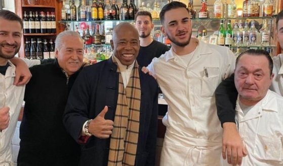 New York Mayor Eric Adams poses indoors sans mask during a visit to Little Italy on Sunday.