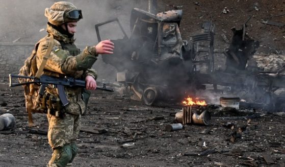 A Ukrainian soldier is seen at the site of a fight with a Russian raiding group in the Ukrainian capital of Kyiv Saturday morning.