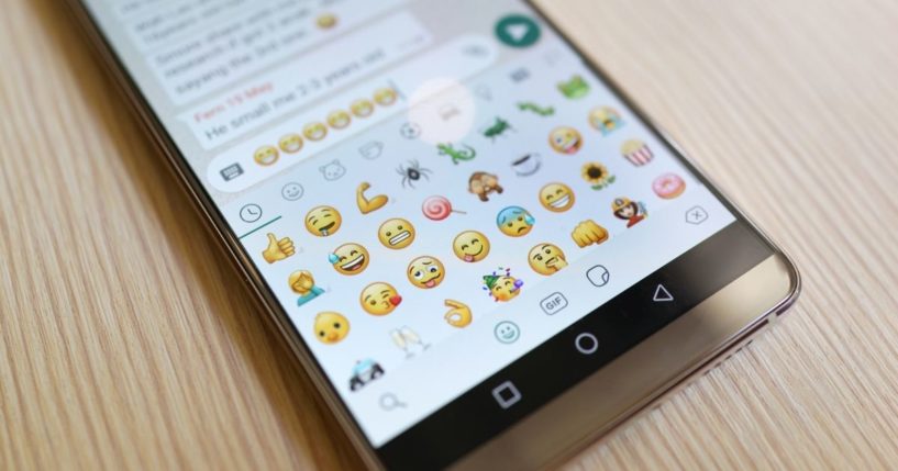 Emojis are displayed on a phone screen in the above stock image.