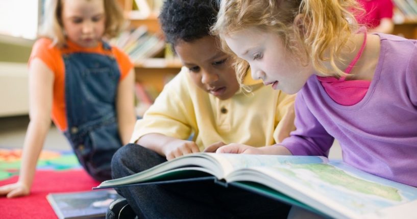 Children read a book in this stock image.