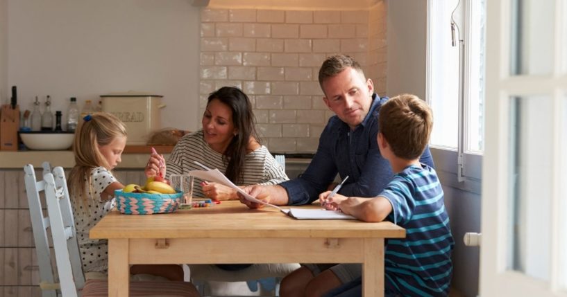 A family sits at a table in the above stock image.