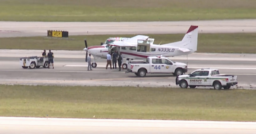 This still image from video by WPTV-TV shows emergency personnel surrounding a Cessna plane at Palm Beach International Airport in West Palm Beach, Florida, on Tuesday. A passenger with no flying experience was able to land the plane safely with help of air traffic controllers after the pilot was too sick to handle the controls.