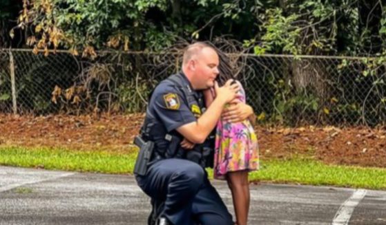 David Snively, interim chief of the Morrow, Georgia, Police Department, takes a moment from his duty to comfort a little girl after an arrest was made.