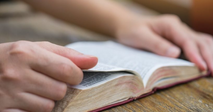 A woman reads the Bible in this stock image.