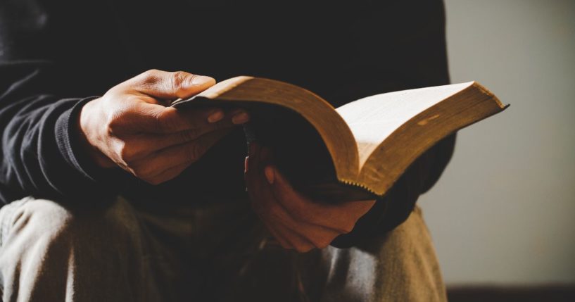 A man reads the Bible in this stock image.