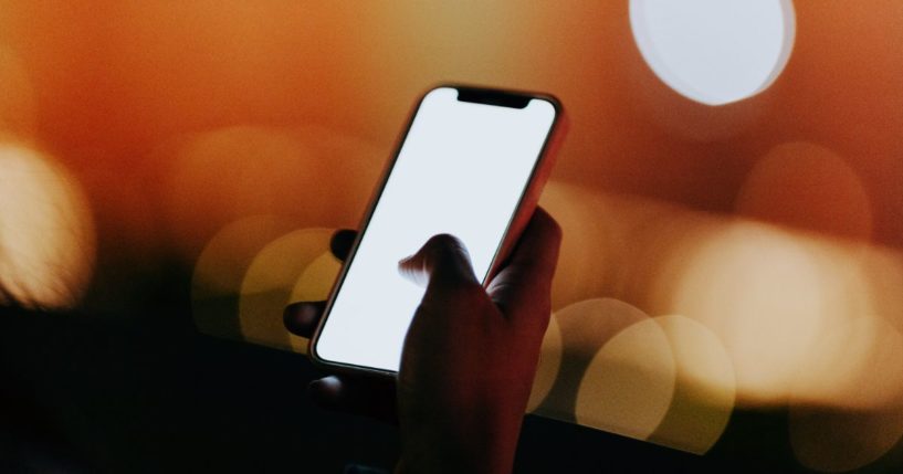 A woman uses a cellphone in the above stock image.