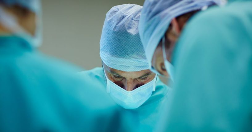 Surgeons performing a procedure in an operating room.