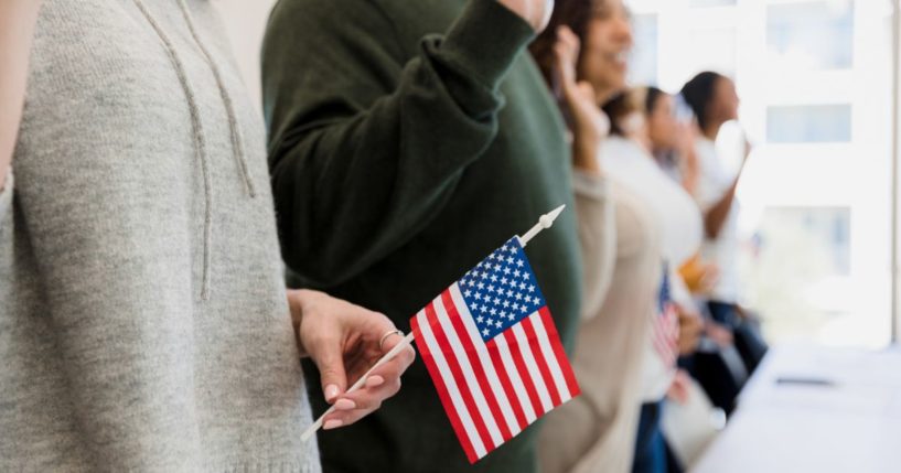 A group of people is sworn in as American citizens in this stock image.