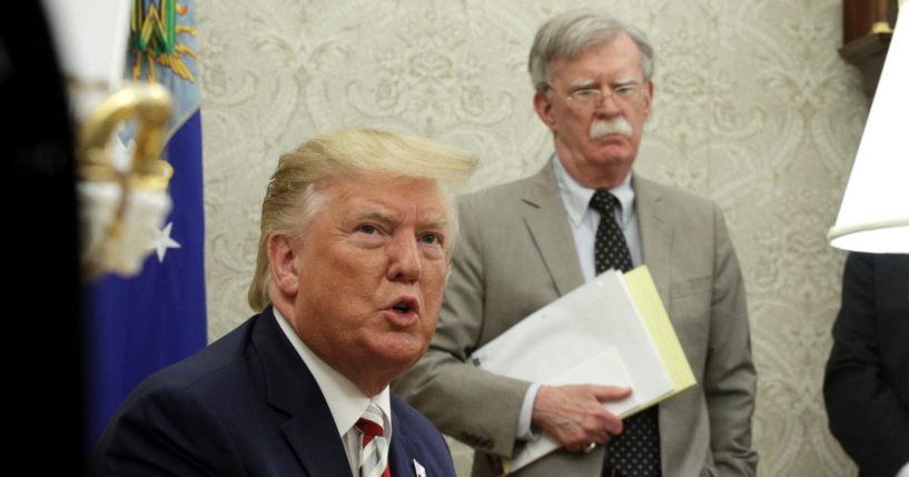 Then-President Donald Trump and his national security advisor, John Bolton, meet with Romanian President Klaus Iohannis in the Oval Office of the White House in Washington on Aug. 20, 2019.