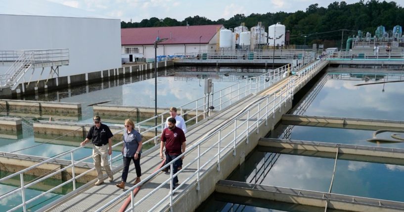 Jim Craig, with the Mississippi State Department of Health, left, leads Jackson Mayor Chokwe Antar Lumumba, right, Deanne Criswell, administrator of the Federal Emergency Management Agency, center, and Mississippi Gov. Tate Reeves, rear, as they walk past sedimentation basins at the City of Jackson's O.B. Curtis Water Treatment Facility in Ridgeland, Miss., Friday.