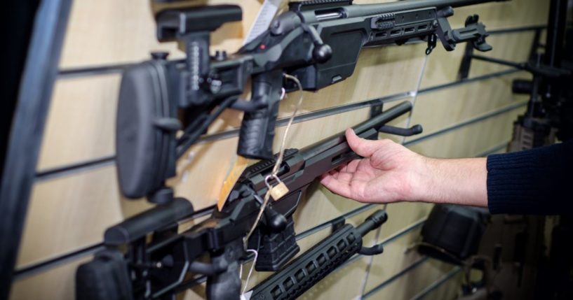 A man picks up a gun in this stock image.