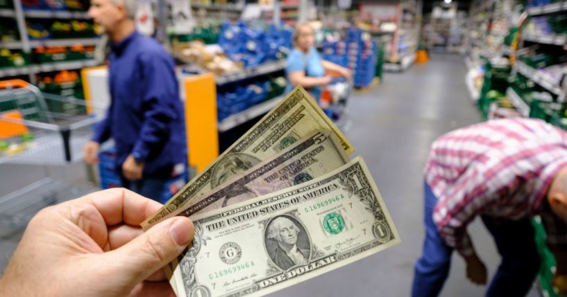 A man holds banknotes in a supermarket on Sept. 2 in Brussels, Belgium.