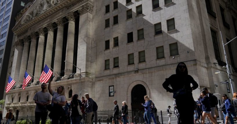 Visitors to the financial district walk past the New York Stock Exchange on Friday.