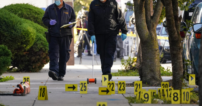 Investigators work the scene where three police officers were injured and a suspect was killed when a SWAT team attempted to serve a homicide warrant on Wednesday.