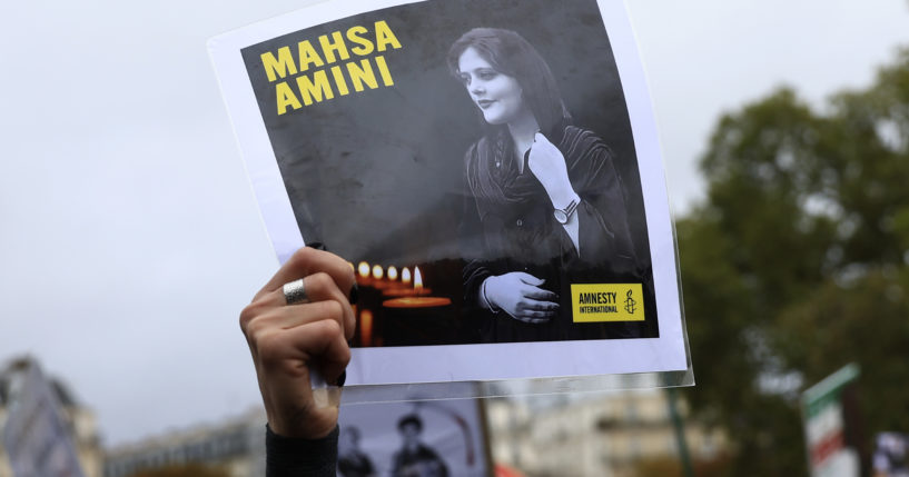 A protester shows a portrait of Mahsa Amini during a demonstration to support Iranian protesters standing up to their leadership over the death of a young woman in police custody on Sunday in Paris.