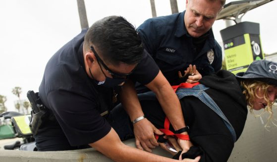 Two LAPD officers take a knife away from a homeless woman as she was detained during an event with Los Angeles City Council Member and mayoral candidate Joe Buscaino announcing his "Plan For A Safer Los Angeles" at Venice Beach on June 7, 2021.